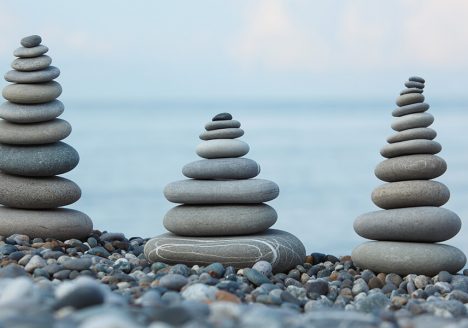 cairn rocks beach sea calm sand sun